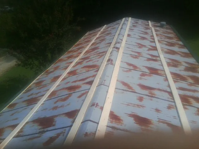 Rusted metal roof panels with new wood purlins before replacement — Storm Damage Roof Repair in Cloverdale by Roofing Brothers
